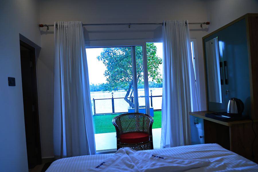 A bedroom with a glass door looking out to the lake