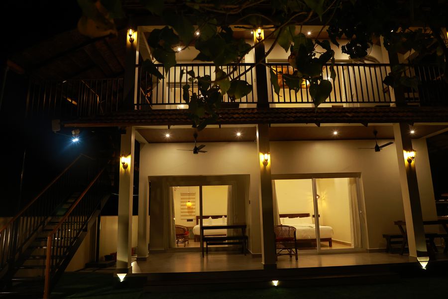 The veranda and upper balcony lit up at night